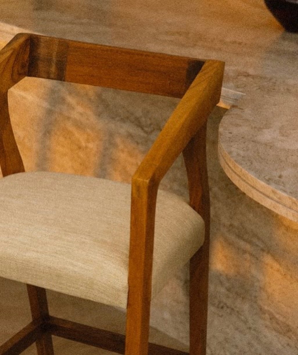 Detalle de silla de madera junto a mesa de mármol